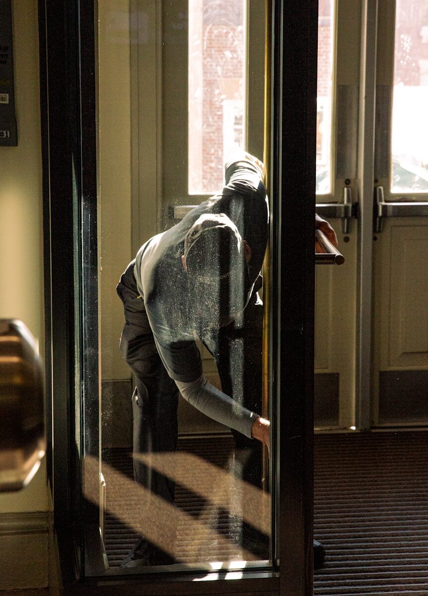 A person looks out a glass door.